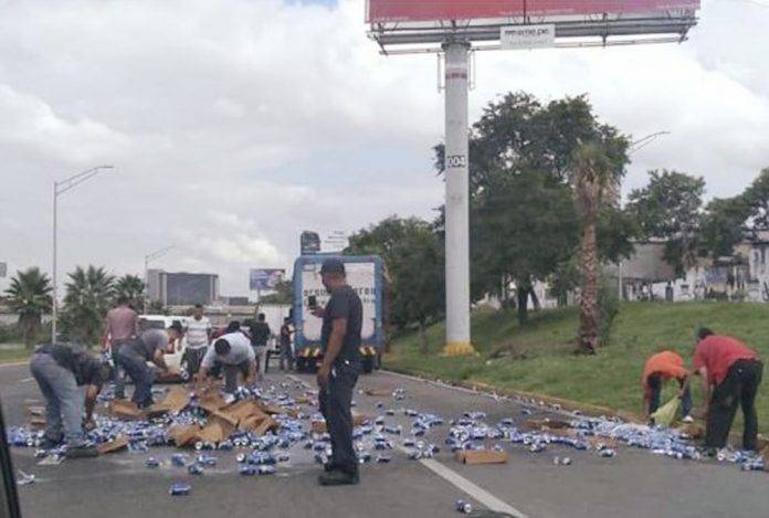 Vecinos saquean camión de cerveza volcado