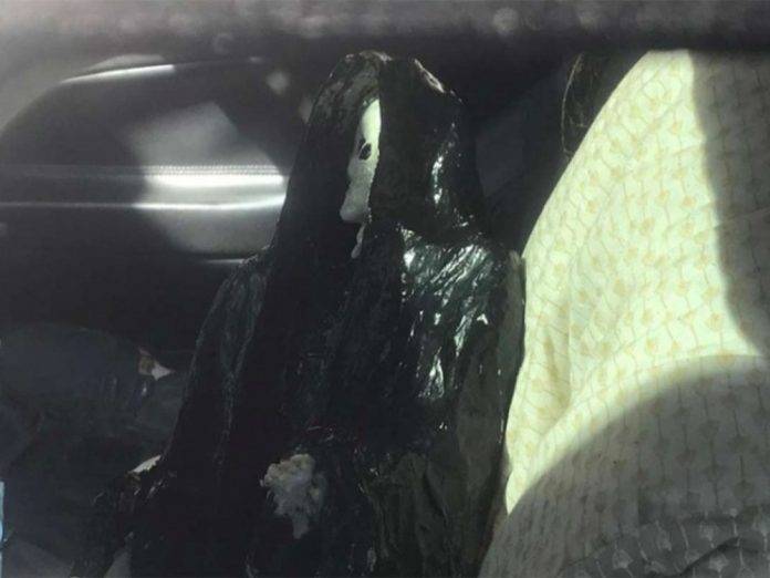 Hallan cadáver en un auto, rodeado de imágenes de santería