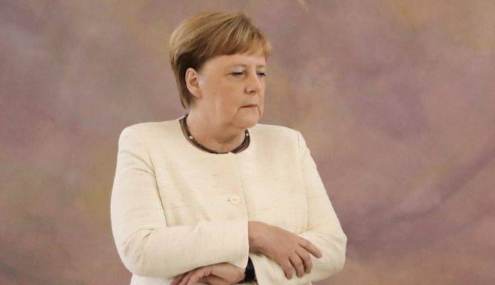 A Angela Merkel le tiembla la mano... literal