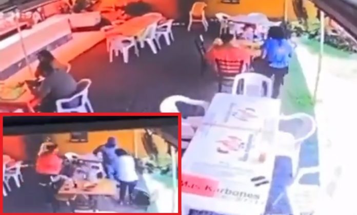 En recuadro el momento en que llega el asaltante a la mesa de las víctimas